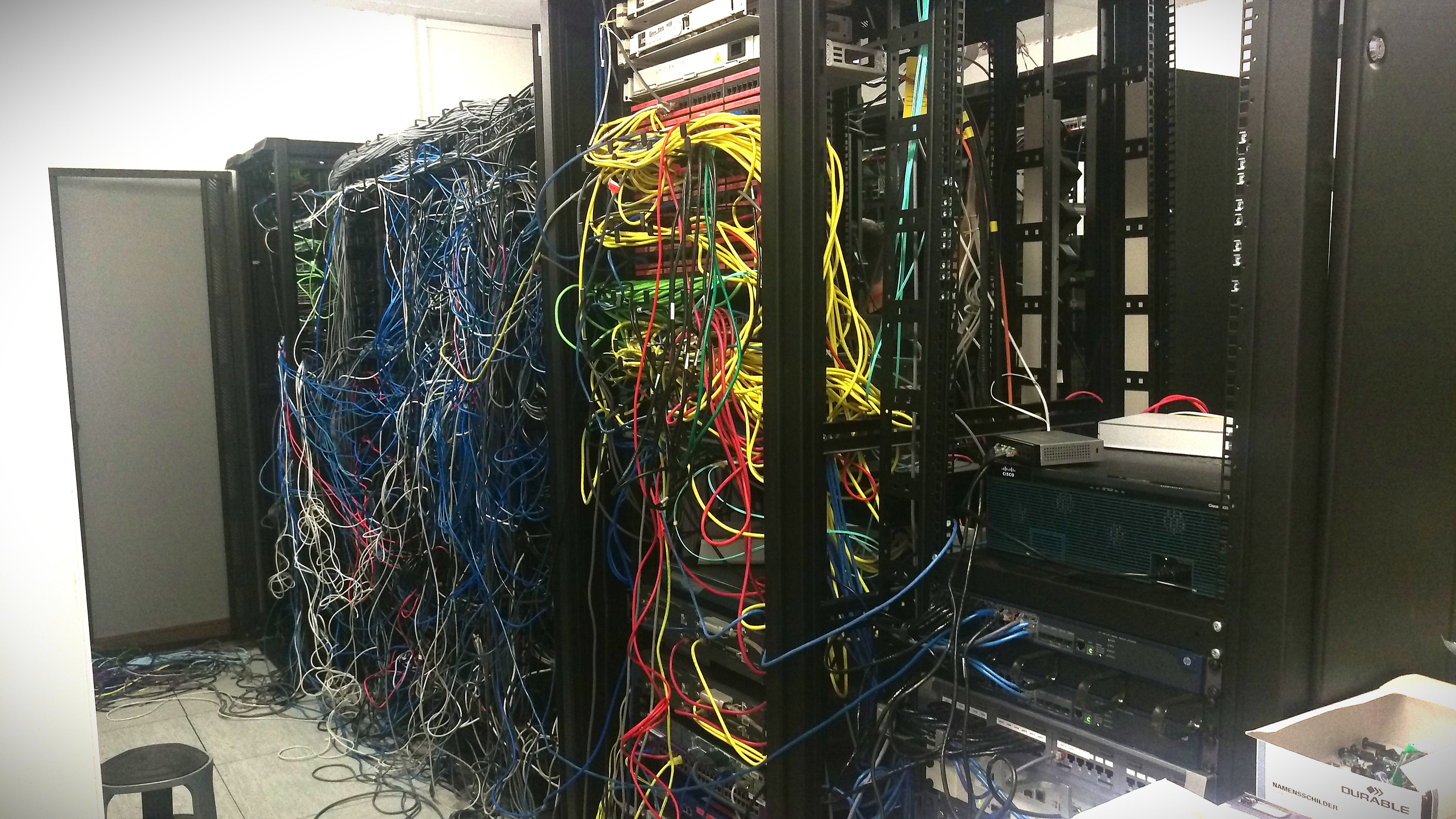 Server cabinet with densely packed colorful cables in a technical setting
