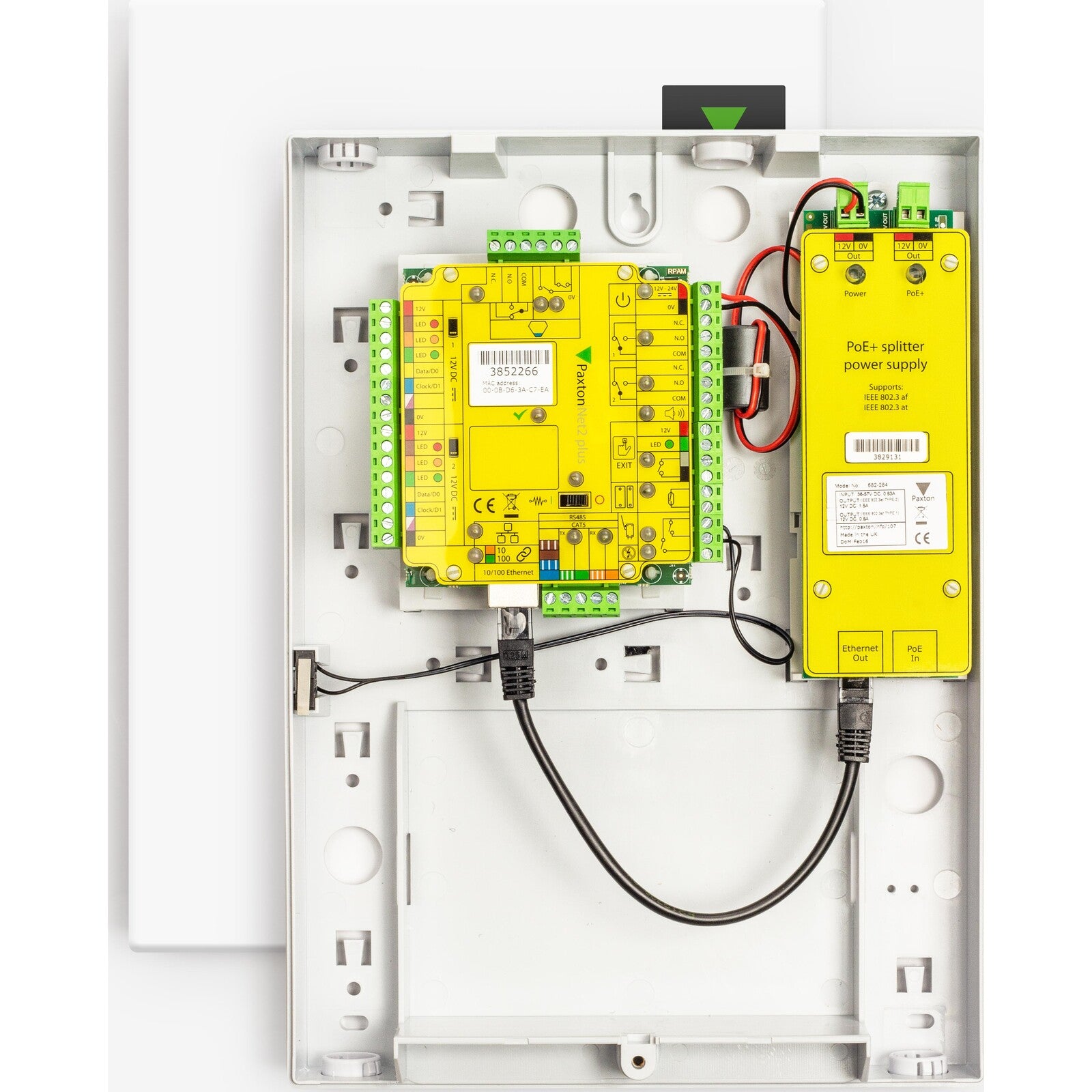 Close-up of electronic components inside a white panel with yellow circuit boards and wiring.