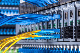 Close-up of network cables and fiber optic connectors in a data center setting.