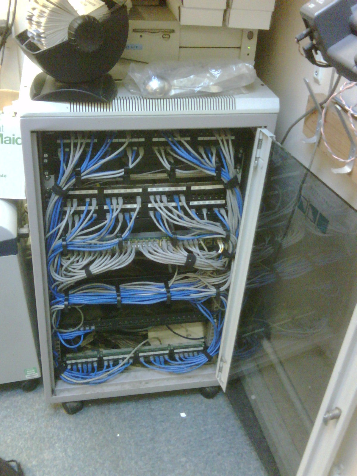 Network switch with numerous cables connected, on a blurred background