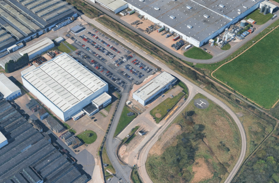 Aerial view of industrial buildings with parking lots and roads.