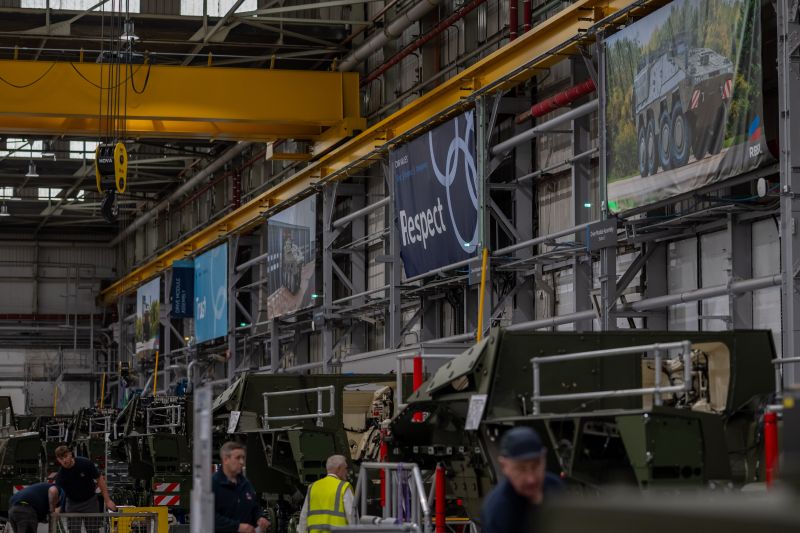 Factory interior with workers and machinery, featuring a 'Respect' banner.